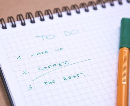 Handwritten to-do list on graph paper notebook with pen. Ideal for organizing tasks.